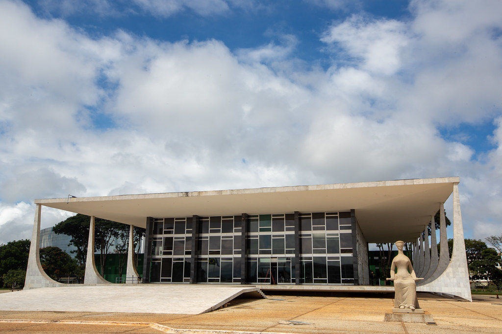 O cenário político nacional enfrenta uma nova onda de questionamentos após uma decisão recente no Supremo Tribunal Federal (STF). O ministro Flávio Dino suspendeu a eficácia da quebra de sigilo bancário e fiscal de Fábio Luís Lula da Silva, filho do presidente Lula, que havia sido aprovada pela CPMI do INSS. Argumentos Jurídicos e a Decisão A medida liminar atende a um pedido da defesa, que contesta a necessidade da devassa nos dados financeiros. De acordo com os advogados, a medida aprovada pelo Legislativo carecia de fundamentação técnica adequada. Consequentemente, o ministro entendeu que a execução imediata da quebra de sigilo poderia causar danos irreparáveis aos direitos individuais antes de um julgamento definitivo. Certamente, a decisão de Dino reacende a discussão sobre o papel do STF em atos do Congresso Nacional. Por um lado, juristas defendem que o Judiciário deve garantir as garantias constitucionais. Por outro lado, críticos e parlamentares de oposição classificam o ato como uma interferência indevida na independência dos Poderes, alegando que o Legislativo tem autonomia para investigar. Repercussão e Próximos Passos Além disso, a suspensão abrange também o acesso a dados de grandes instituições financeiras ligadas ao caso. Notavelmente, a decisão ocorre poucos dias após o ministro André Mendonça ter autorizado quebras semelhantes em uma investigação paralela da Polícia Federal, o que gera um conflito de interpretações dentro da própria Corte. Afinal, o caso deve seguir para análise do plenário do STF, onde os demais ministros decidirão se mantêm ou revogam a liminar de Dino. Portanto, os próximos capítulos desta disputa jurídica serão fundamentais para definir os limites da atuação das Comissões Parlamentares de Inquérito frente às garantias de sigilo.