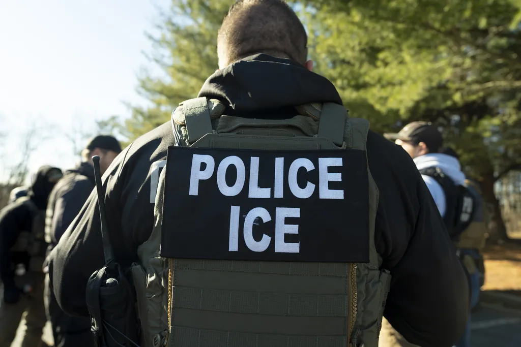 Agentes do ICE realizando uma operação de custódia em uma rua residencial de Los Angeles.