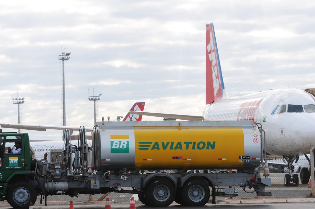 Aeronave comercial sendo abastecida em um pátio de aeroporto com caminhão de combustível da Petrobras.