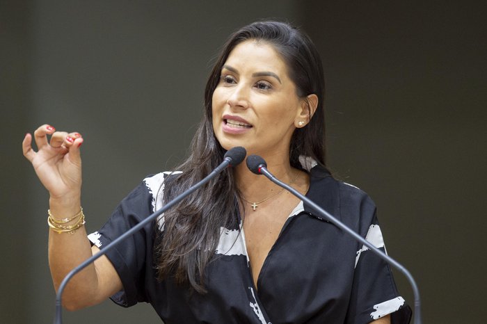 Foto da vereadora Mariana Lescano ao lado de logotipos das marcas Ypê e Minuano, ilustrando a denúncia de favorecimento comercial.