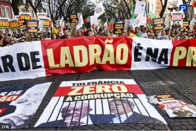 Idosos segurando faixas de protesto em uma rua de Camaçari, na Bahia, cobrando o presidente Lula sobre o dinheiro dos aposentados.