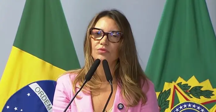Primeira-dama Janja da Silva discursando em púlpito oficial de madeira no Palácio do Planalto durante evento público.