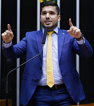 Deputado André Fernandes e assessor em frente ao MPCE segurando documentos da denúncia sobre a operação em Acopiara.