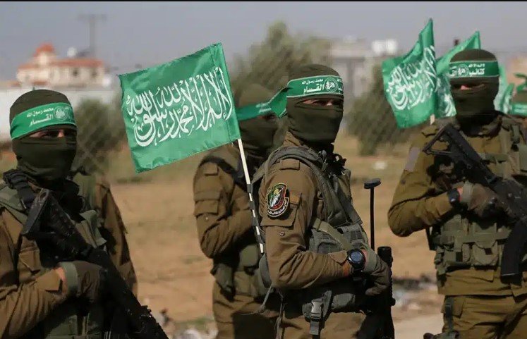 Vista aérea de edifícios danificados na Faixa de Gaza com bandeiras palestinas, simbolizando a transição política anunciada pelo Hamas.